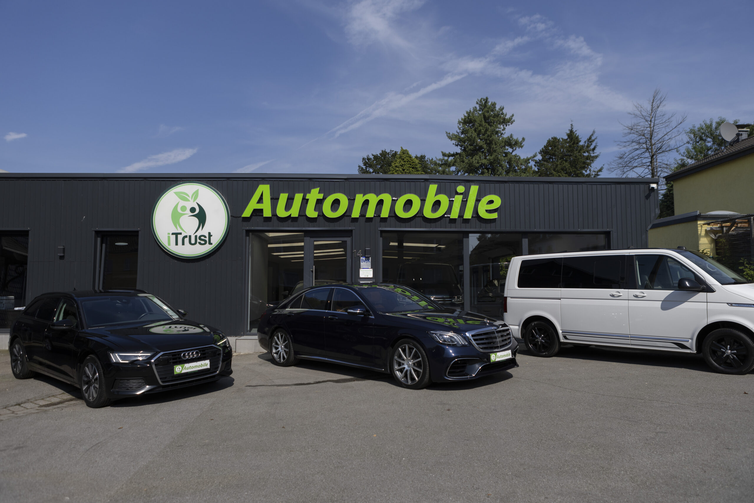 Das Autohaus von Autoankauf iTrust Automobile mit einem Audi, Mercedes und VW vor dem Gebäude in Solingen.