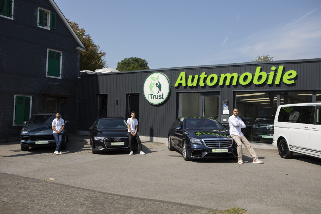 Das Team von iTrust Automobile vor dem Autohaus mit Gebrauchtwagen in Solingen.