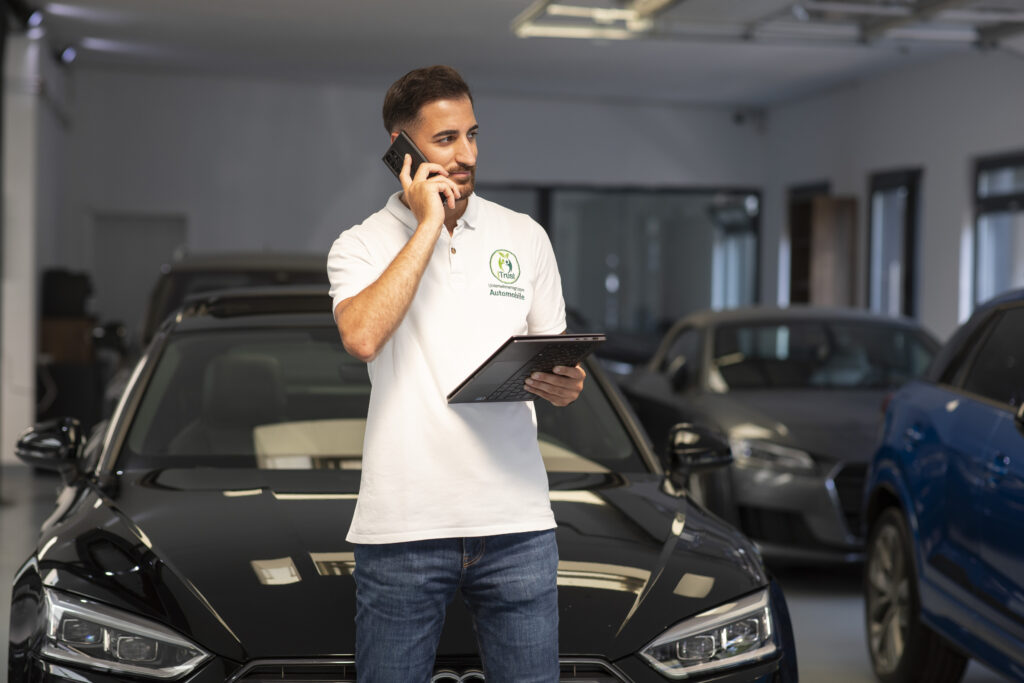 Suleyman Tün von iTrust Automobile organisiert telefonisch die Fahrzeugzulassung in Solingen.